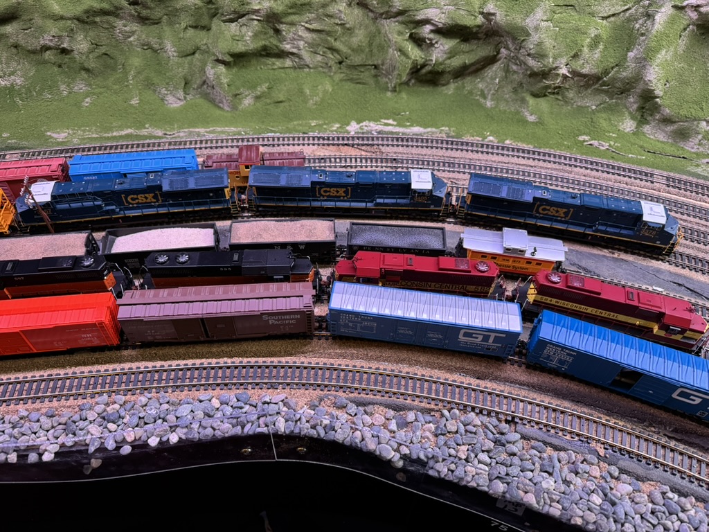 Large CSX staging yard with dozens of locomotives and freight cars on multiple tracks.